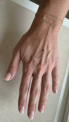 Bracelet permanent bijou de main en vermeil avec pierre verte, posé sur la main par Atelier Moja Bijoux